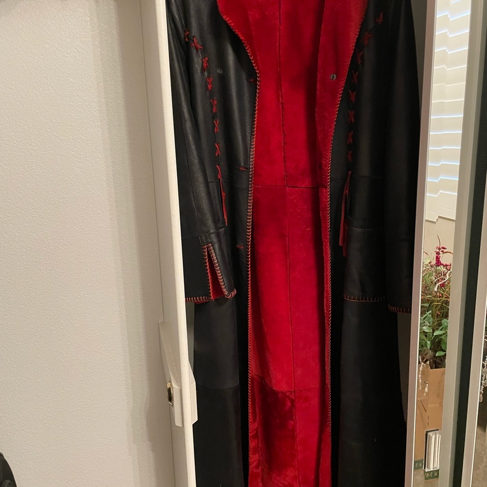This is long under knee leather coat with red fabric inside
